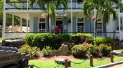 The exterior of the Dockyard Museum, a 2 story building with palm trees in front