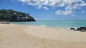 Homes built into a hillside next to a tranquil beach