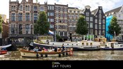 Barcos flotando en el agua frente a edificios de Ámsterdam