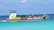 A tour boat filled with Guests, stopped in shallow waters