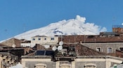 Una cima nevada con vistas a los tejados en Catania