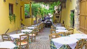 An alleyway in Chania, Greece featuring covered and outdoor seating