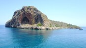 The rocky islet of Thodorou with a prominent cave surrounded by the sea in Chania, Greece