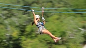 A woman riding a zip line in a seated position