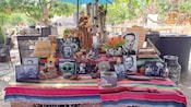 A Day of the Dead altar with flowers, trinkets, a statue of a saint and photographs of loved ones
