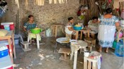Mexican women preparing traditional food inside a thatched roof hut