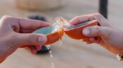 Two hands using sipping bowls to toast tequila