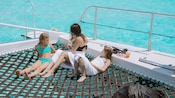 A mother and her 2 daughters enjoying a beverage on a catamaran at Safehaven Marine in Grand Cayman