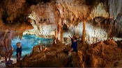Uma mulher e dois meninos observando as estruturas de cristal em uma caverna subterrânea