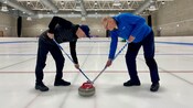 2 curlers sweeping the ice