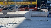 An outdoor setting with an art installation featuring metal silhouettes of The Beatles