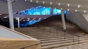 O saguão da sala de concertos Elbphilharmonie em Hamburgo com iluminação natural, arandelas modernas e pisos e escadas de madeira