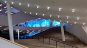 The foyer of the Elbphilharmonie Concert Hall in Hamburg with natural lighting, modern ceiling sconces, and wooden floors and stairs