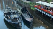 Dos barcos históricos en el río Ilmenau, amarrados a lo largo de un comedor al aire libre con edificios históricos que bordean el río