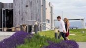 Una pareja caminando fuera de un edificio con flores