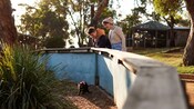 A young couple admiring a furry animal in an enclosed pen