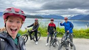 2 teenagers and their parents standing beside their electronic bikes at the edge of a lake on North Douglas Island