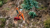 Uma mulher com capacete praticando tirolesa em Maui, Havaí