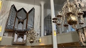 O interior da Igreja de São Nicolau com candelabros e um piano eletrônico