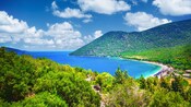 Un exuberante paisaje montañoso que rodea el agua transparente y la costa