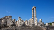 Ruins of an ancient Greek temple adorned with intricate stone columns and carvings