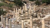 Tourists exploring the ruins of a street lined with ancient columns