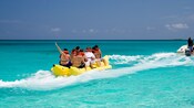 8 people riding on a Banana Boat pulled by a motorboat