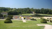 A verdant courtyard with flower gardens and a large pond