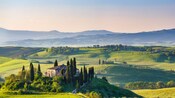 A villa in a valley along the Italian countryside featuring mountains against the skyline