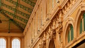 The interior of an art nouveau style building with ornate molding and wrought iron