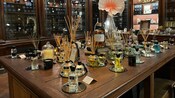 A table with bottles of perfume, candles and oil diffusers