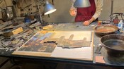 A person creating a mosaic artwork at a workshop