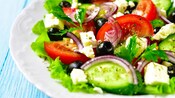 A salad featuring tomatoes, olives, red onion, feta and cucumbers