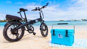 A bicycle parked on a beach next to a cooler in Nassau, The Bahamas