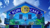 Um prédio com a pintura de um navio na fachada e uma placa que diz "Bahamas Rum Cake Factory"