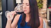 A woman taking a sip of wine