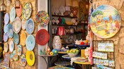 A street market stall with ceramic plates and ornaments for sale