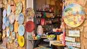 Un puesto del mercado callejero con platos y adornos de cerámica para la venta