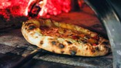 A Neapolitan pizza baking in a rustic wood oven