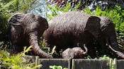 Two adult elephants and a calf made of rattan in a garden at Brooklands Zoo in New Zealand