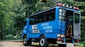 The rear of a large touring truck, with stairs leading up to the seating area