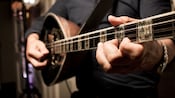A musician plays a traditional Greek instrument called a bouzouki