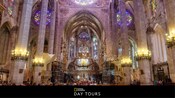 Columnas que bordean la nave de una catedral gótica decorada con vitrales