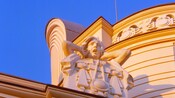 A bust of a man crying out in anguish with his hands on his head, fixed atop a rooftop