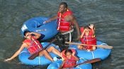 Uma mãe e um pai com seus dois filhos em botes infláveis no Wacky River, em Dominica