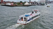 A boat along the Port of Rotterdam with ‘River Cruise Rotterdam’ written on the vessel’s surface
