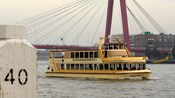 A riverboat sailing near a bridge