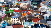 Casas de vários andares bem agrupadas com laterais e telhados de cores vibrantes