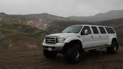 A 6 door modified Ford F 350 Excursion on a dirt road in Iceland 