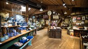 El interior de un almacén general con una decoración de estilo rústico y artículos que incluyen velas, cerámica y otros objetos para el hogar